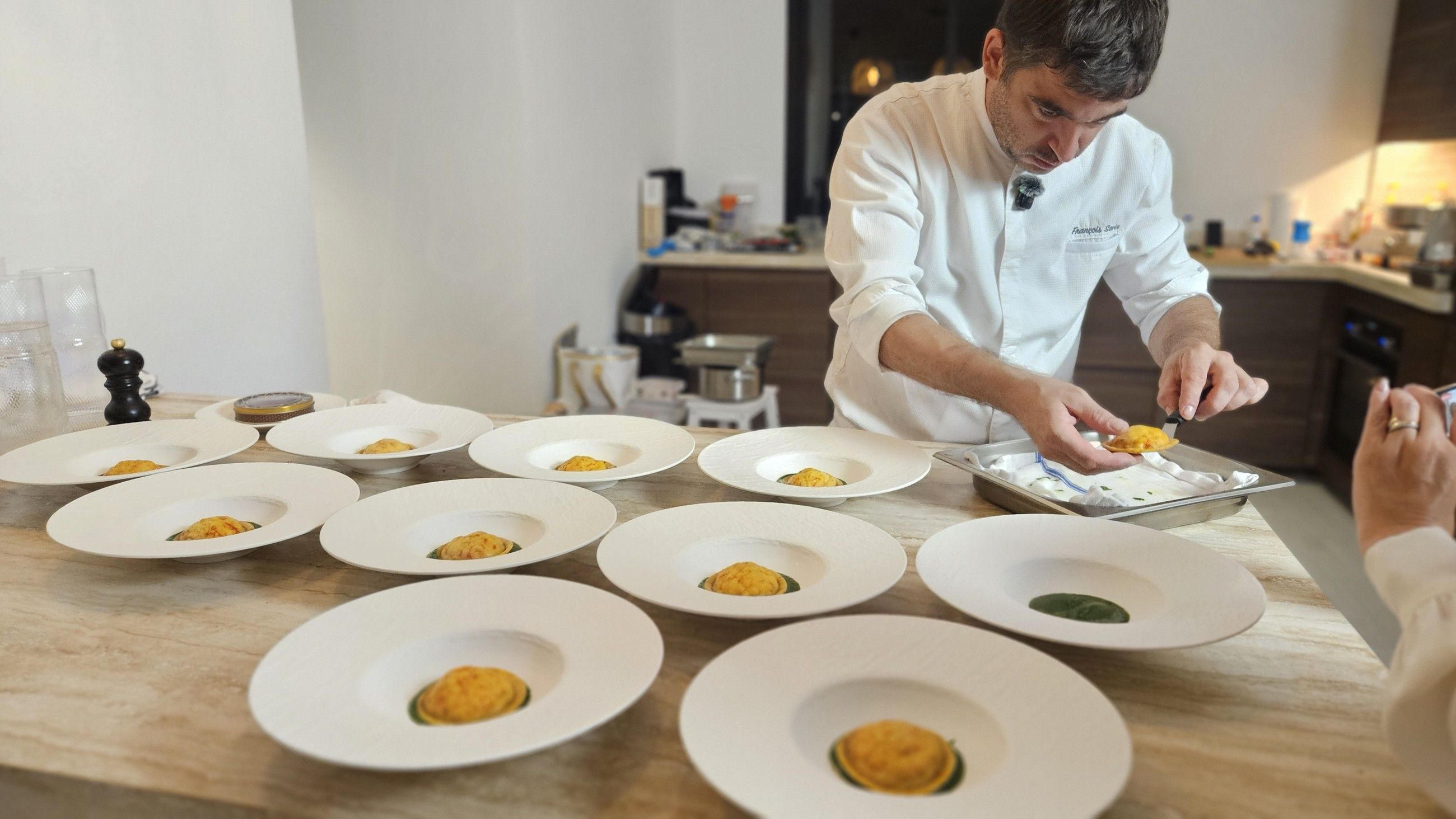 Chef François Savin plating the first course in a villa kitchen.