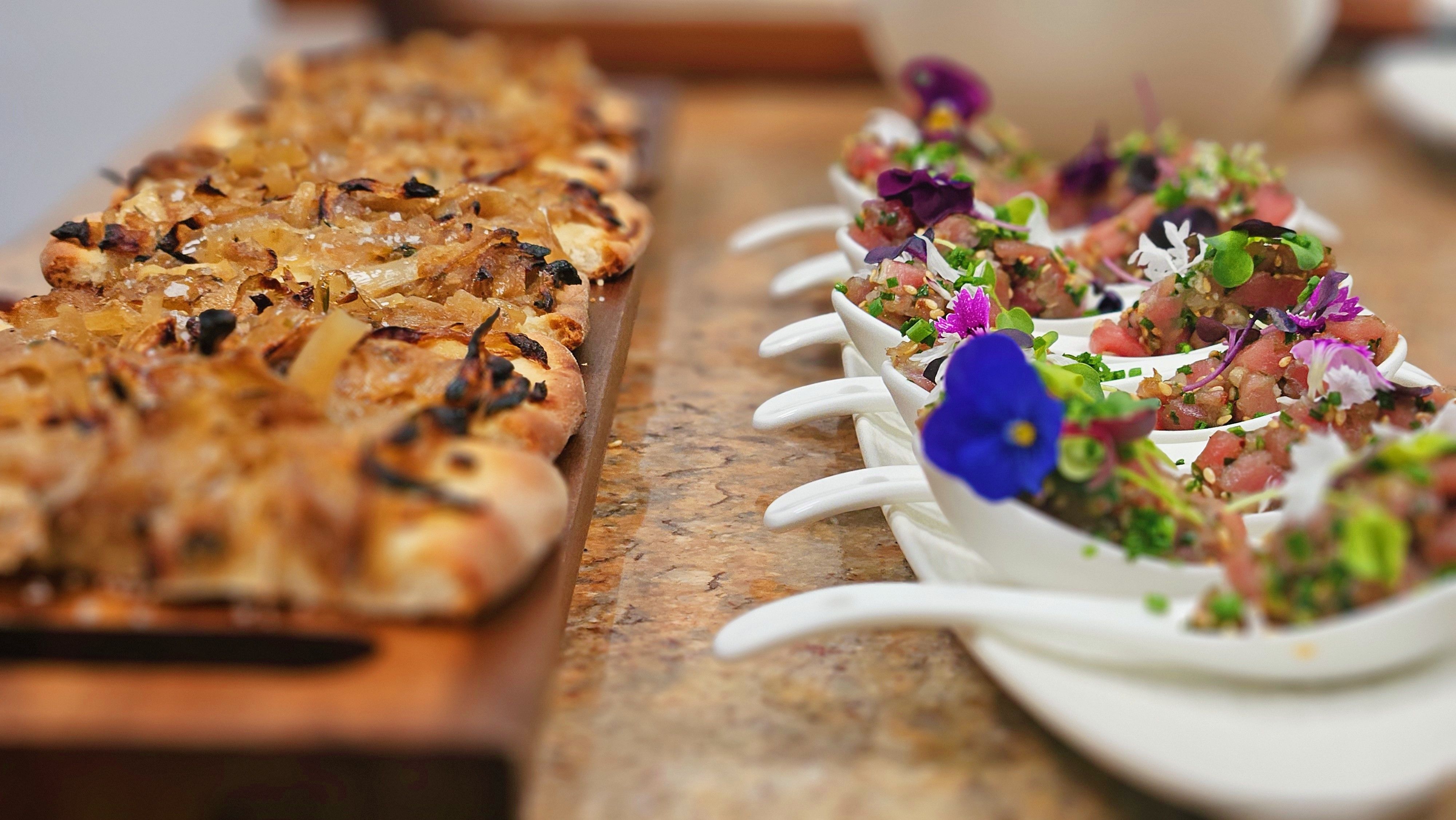 Amuse-bouche spoons topped with edible flowers.