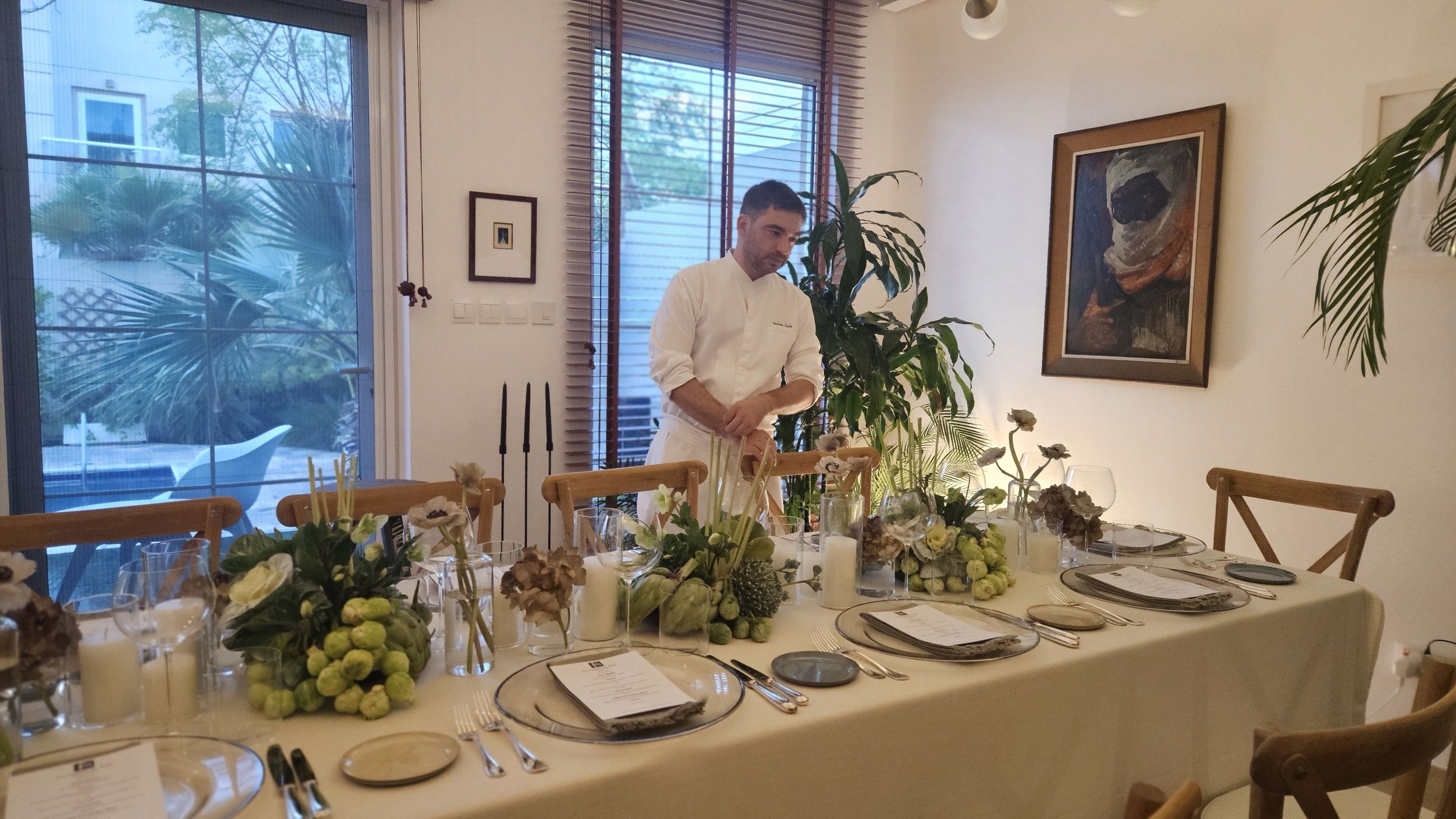 The chef giving a long dinner table its final look.