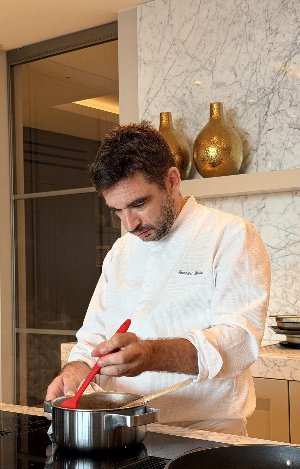 Chef Savin working a sauce in a villa kitchen.