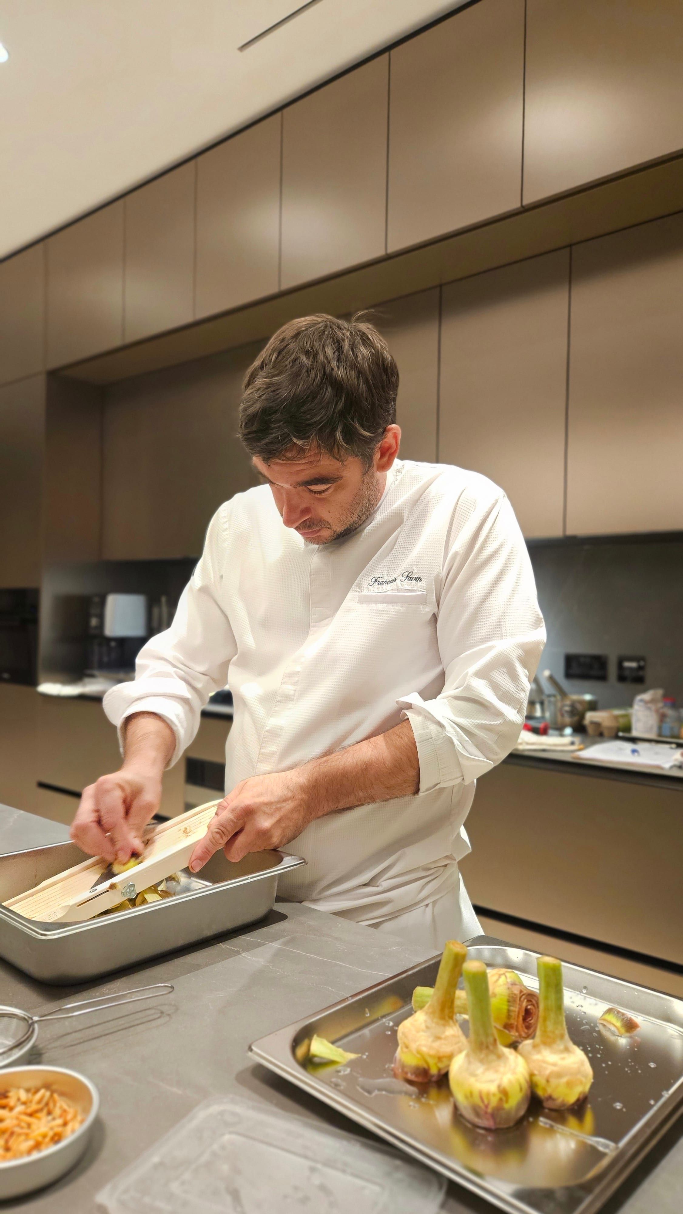 Chef François Savin plating a course in the kitchen.