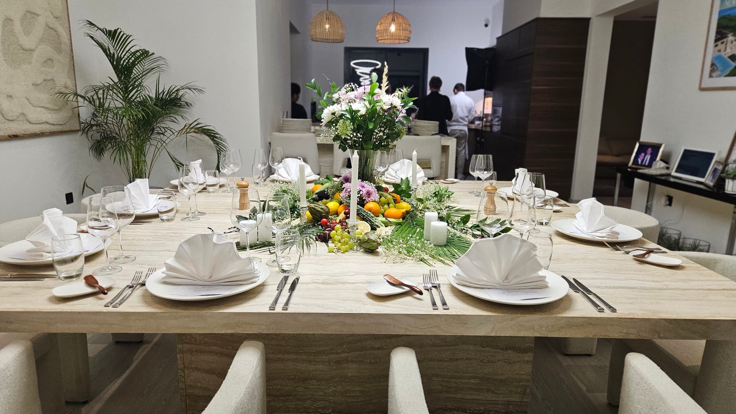 A Dubai villa table dressed for dinner, candles and white flowers.