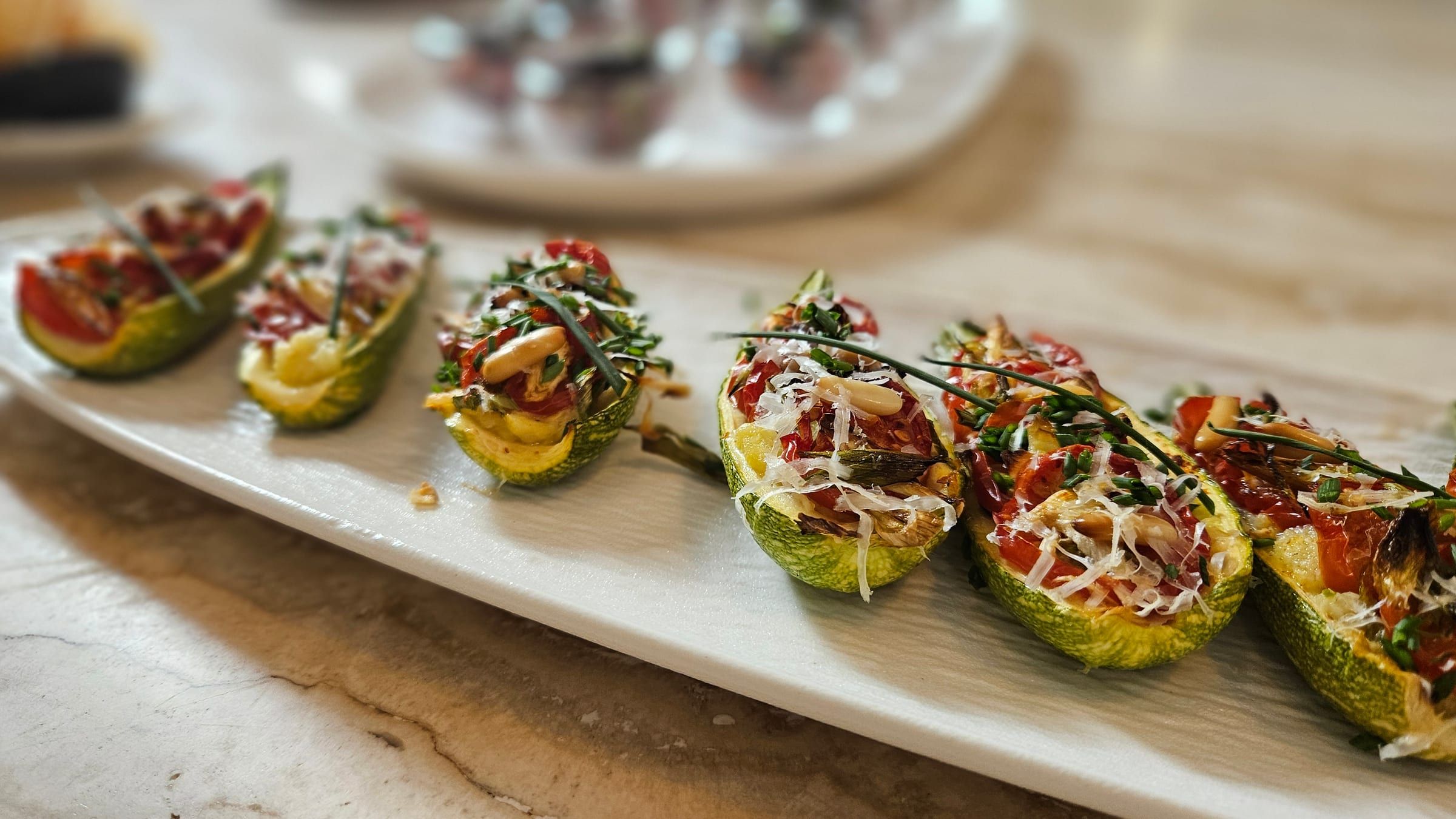 Stuffed courgette-flower canapés on a marble table.