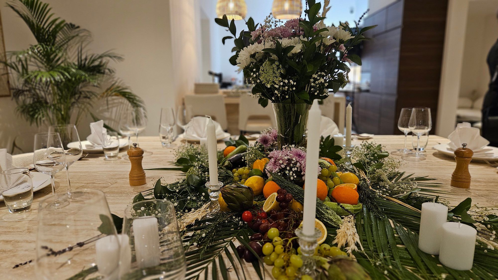 A long table dressed in white linen and candlelight in a Dubai villa, set for a private dinner.