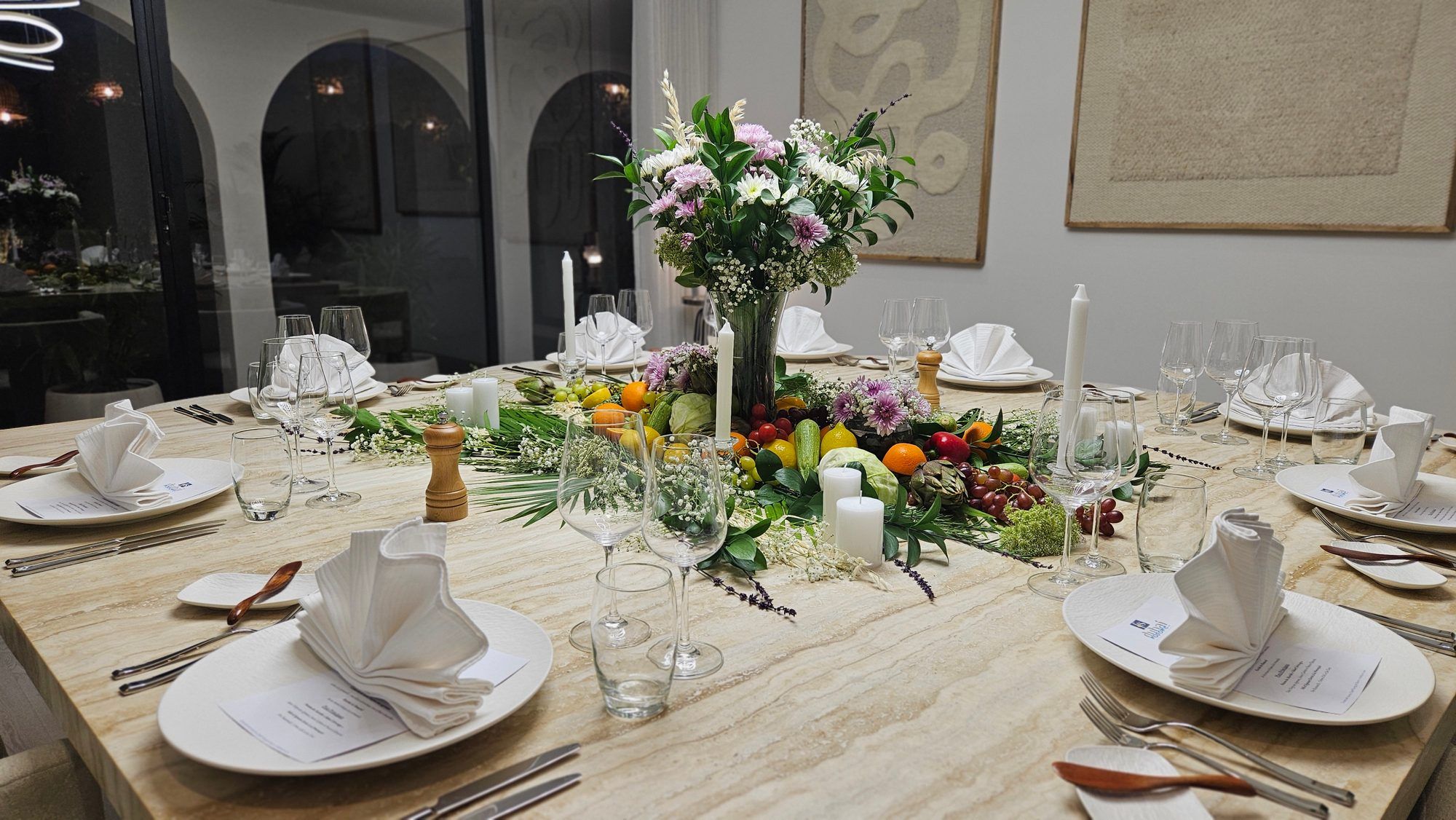 Villa table with a runner of fresh produce and candles.