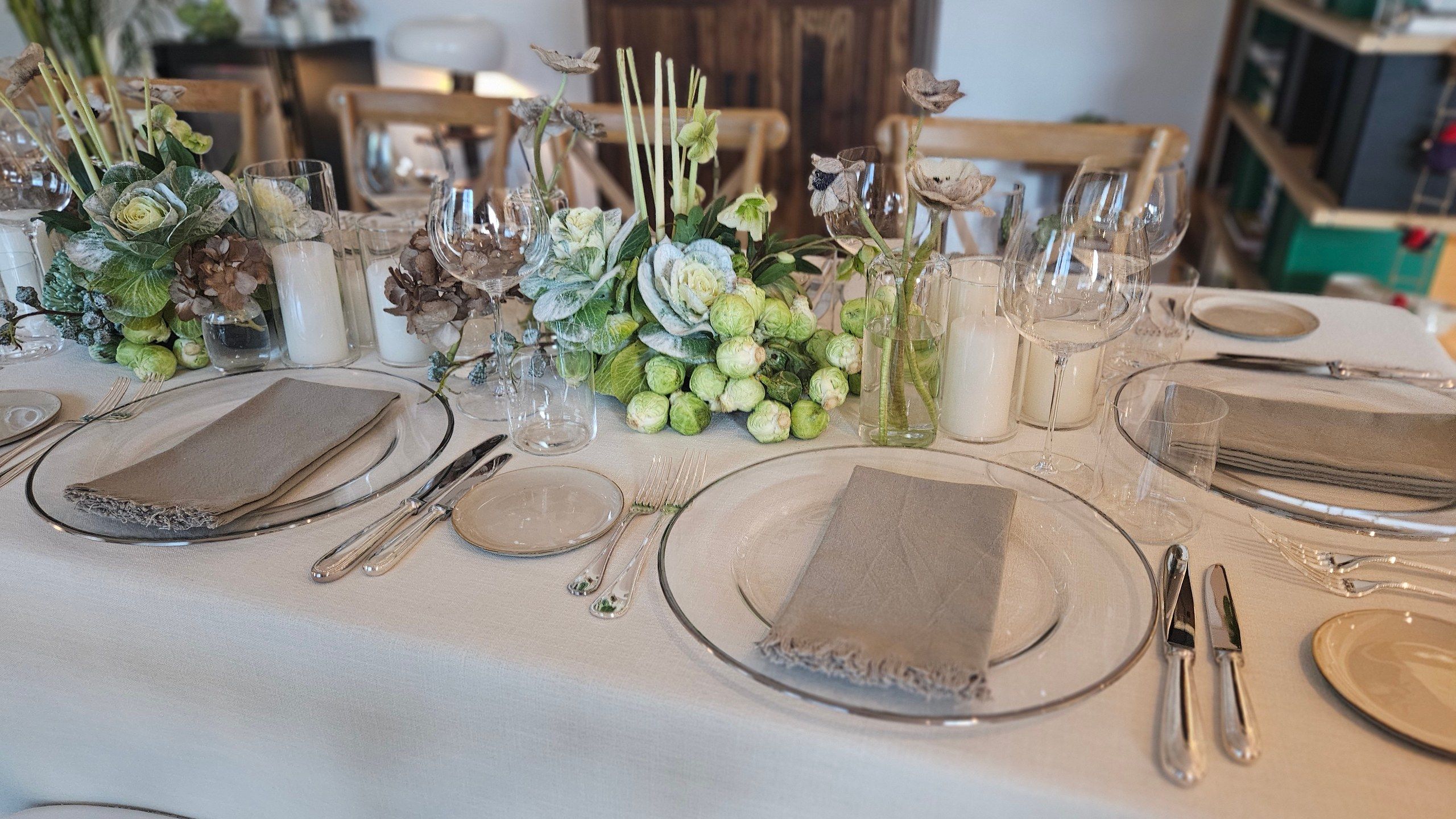 An elegant table dressed in white florals and silver for a wedding reception