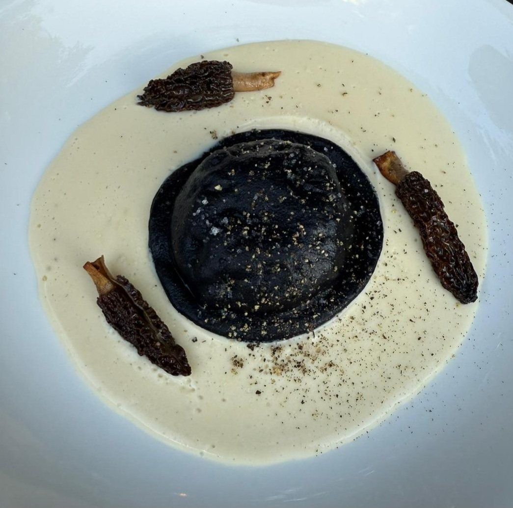Squid-ink ravioli on a white morel-cream sauce, dressed with seared morels.