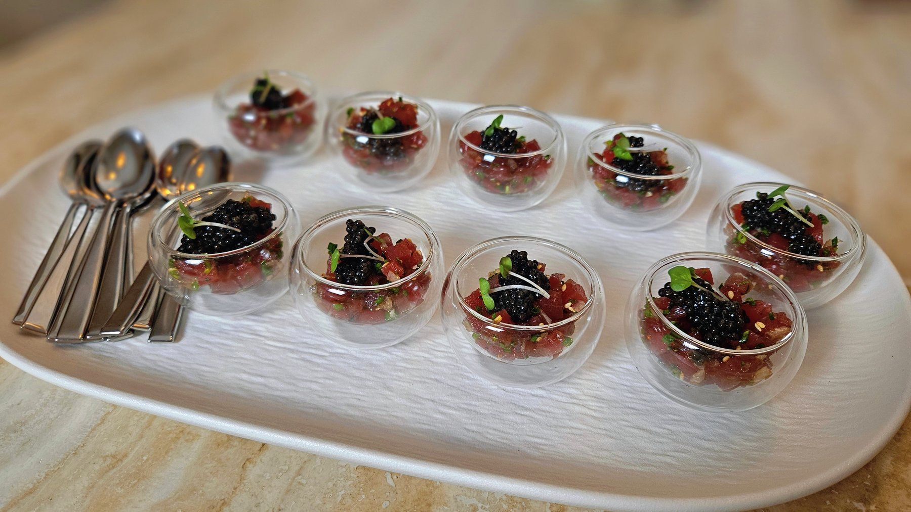 Tartare and caviar served in glass spoons.