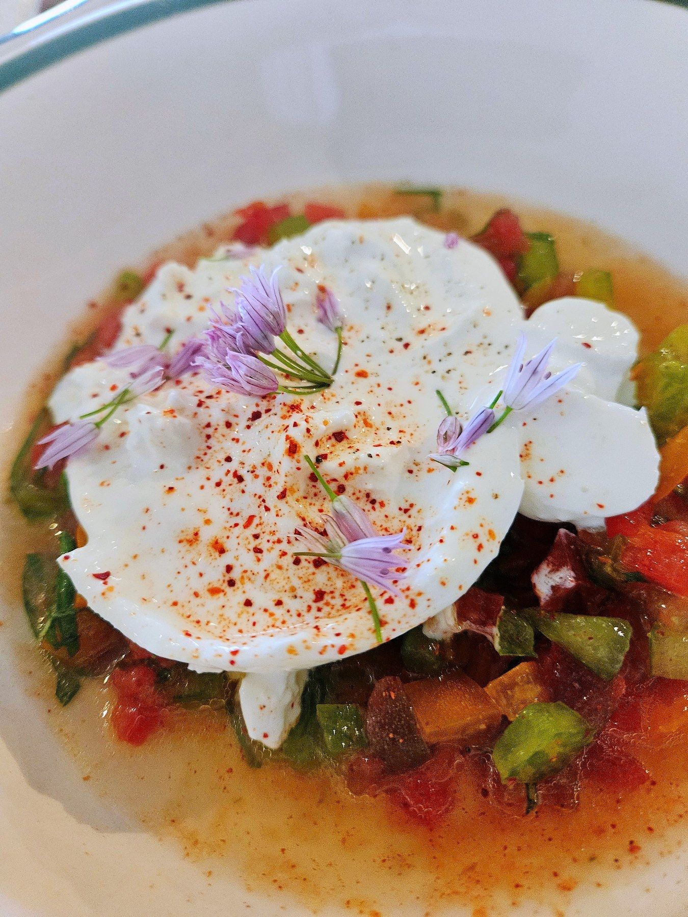 Risotto with edible flowers on a small plate.