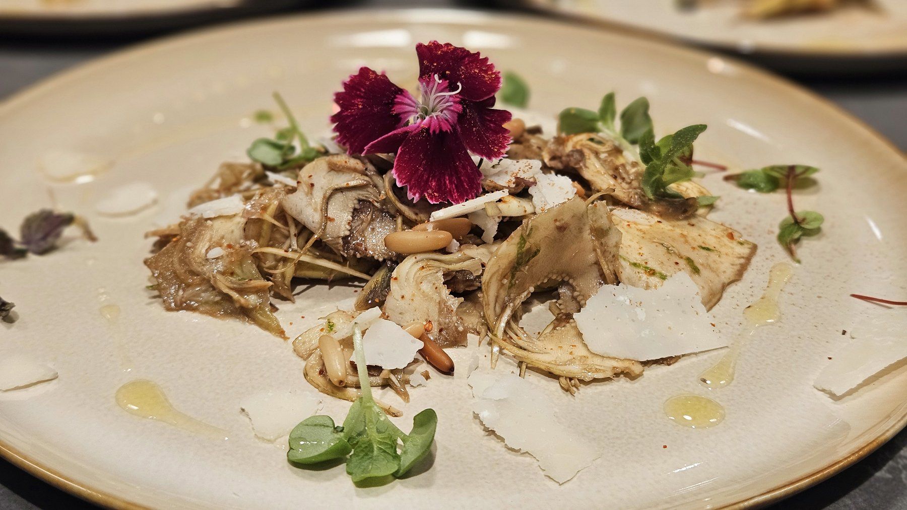 Fish with artichoke, parmesan and an edible flower.