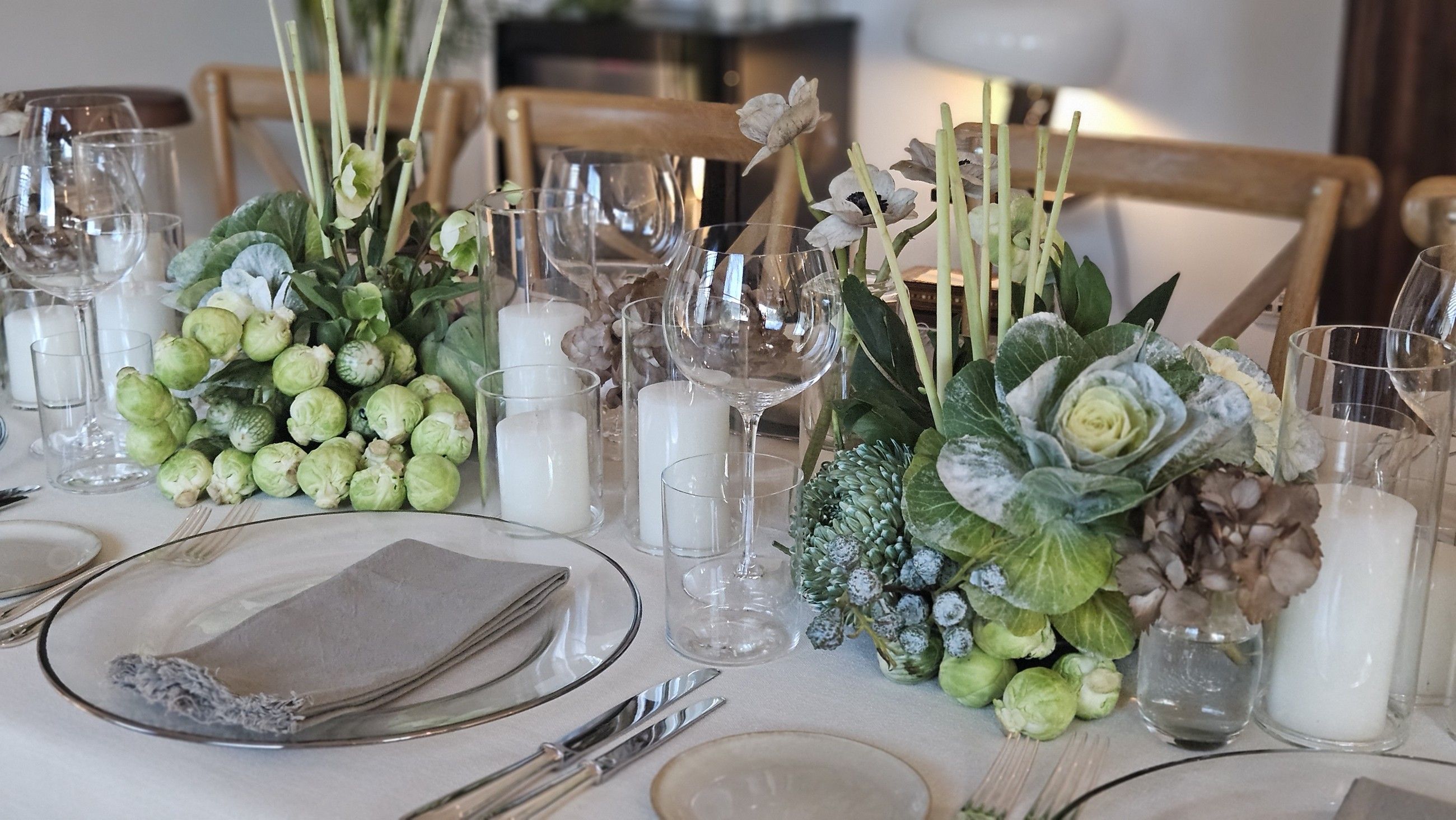 Place setting with candles and white floral centrepieces.