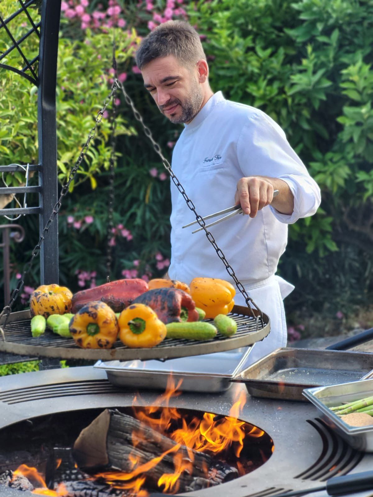 Chef François Savin plating tuna tartare on dark plates, close to the camera in a bright kitchen.