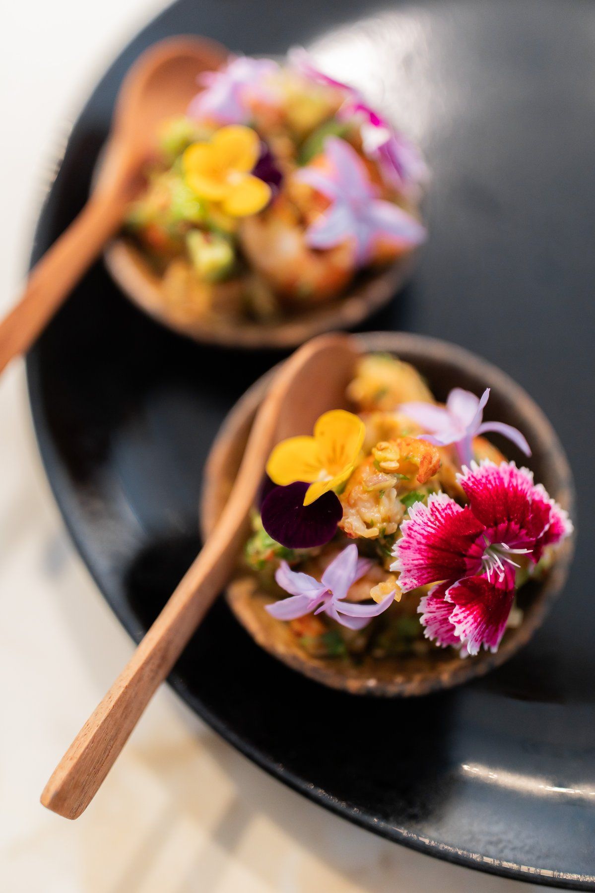 Amuse-bouche spoons dressed with flowers.